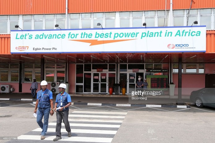 Employees exit the newly renovated energy generation plant, operated by Egbin Power Plc, beneath a branded entrance sign in Lagos, Nigeria, on Wednesday, Aug. 26, 2015. While Nigeria was the world's fourth-biggest exporter of liquefied natural gas in 2012, it's struggling to meet local demand for the fuel used by plants that generate at least 70 percent of the country's electricity needs. Photographer: George Osodi/Bloomberg
